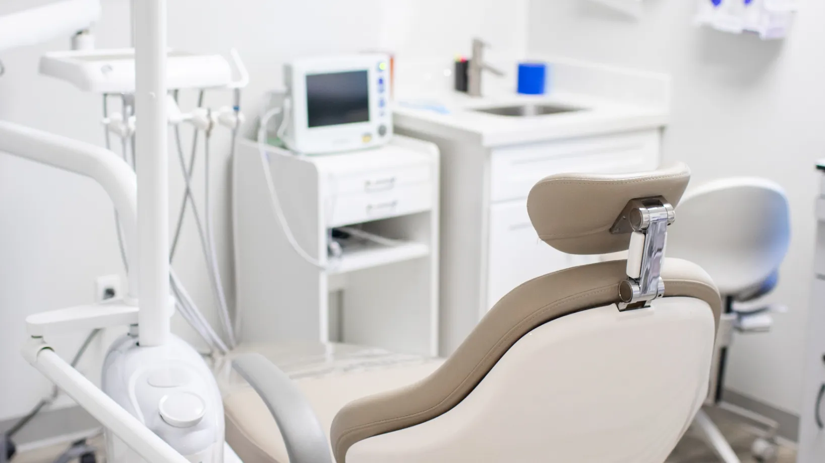 A woman sits at a desk, talking on the phone, with a computer display in front.