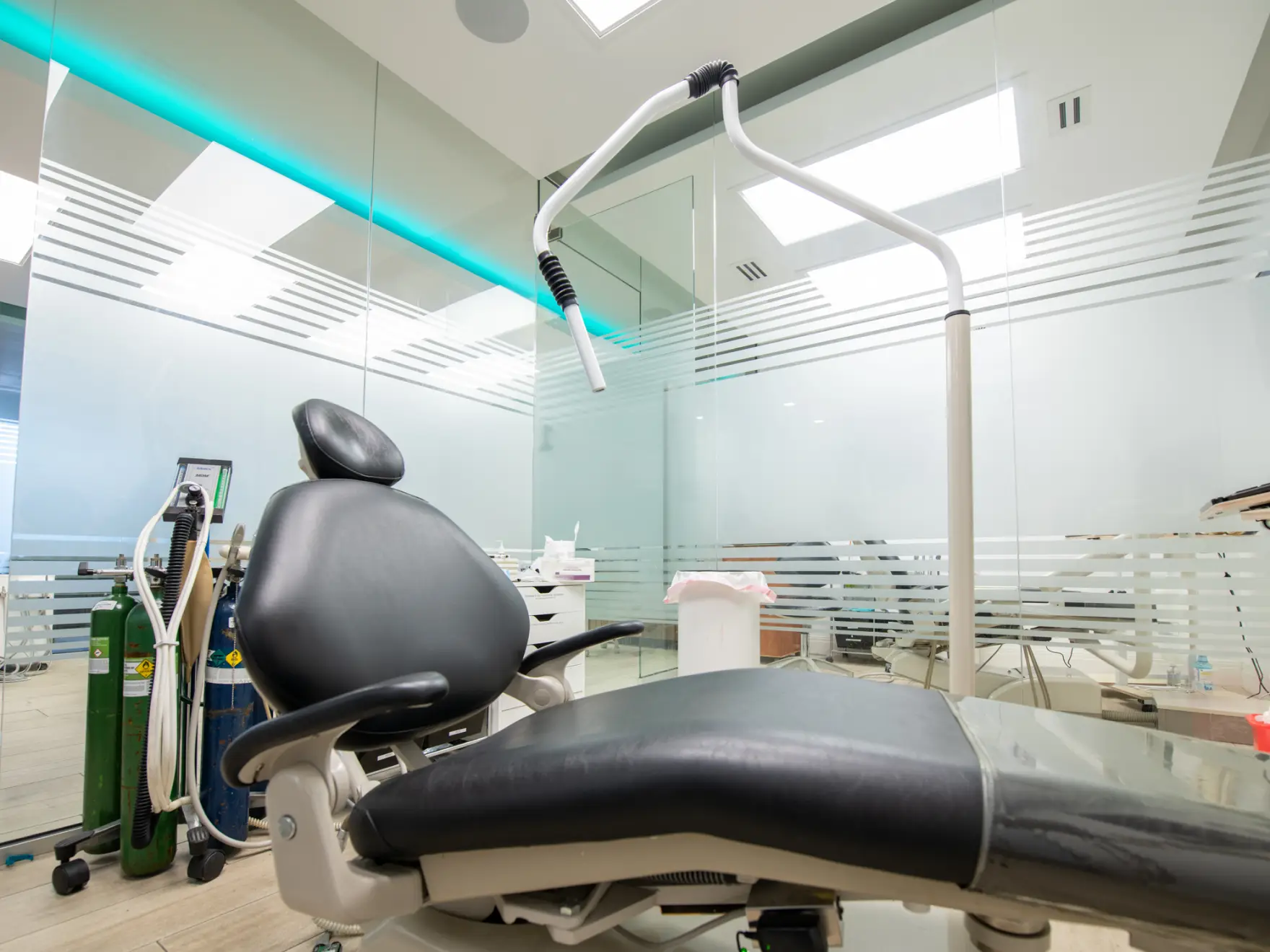 A dental chair in a modern dentist's office, with medical equipment in the background.