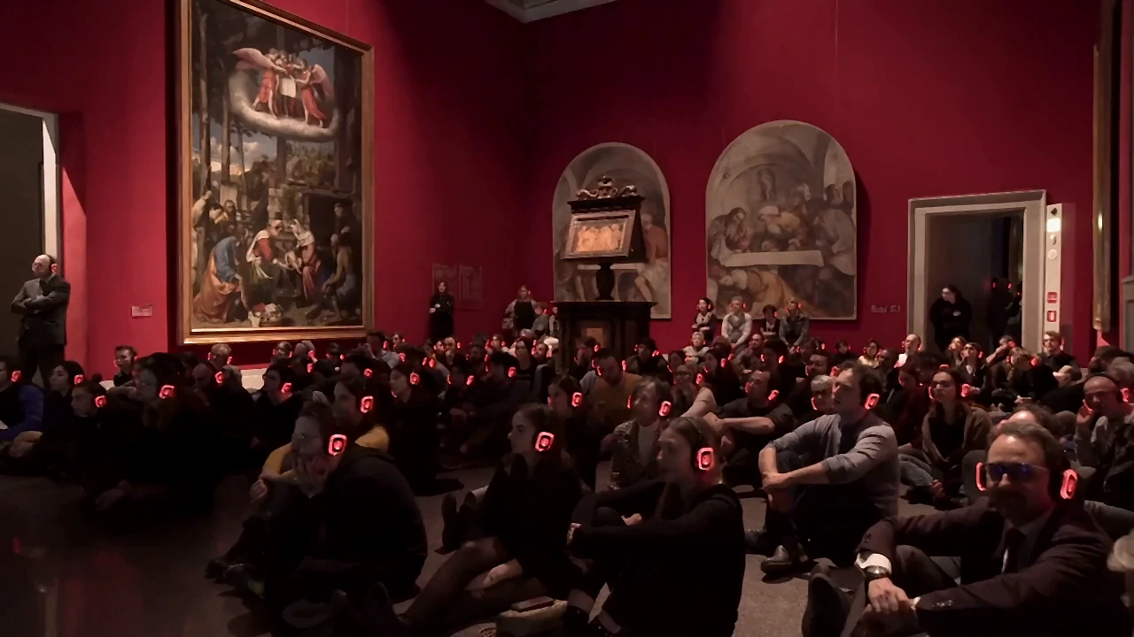 Público sentado con auriculares en la sala de un museo durante una sesión