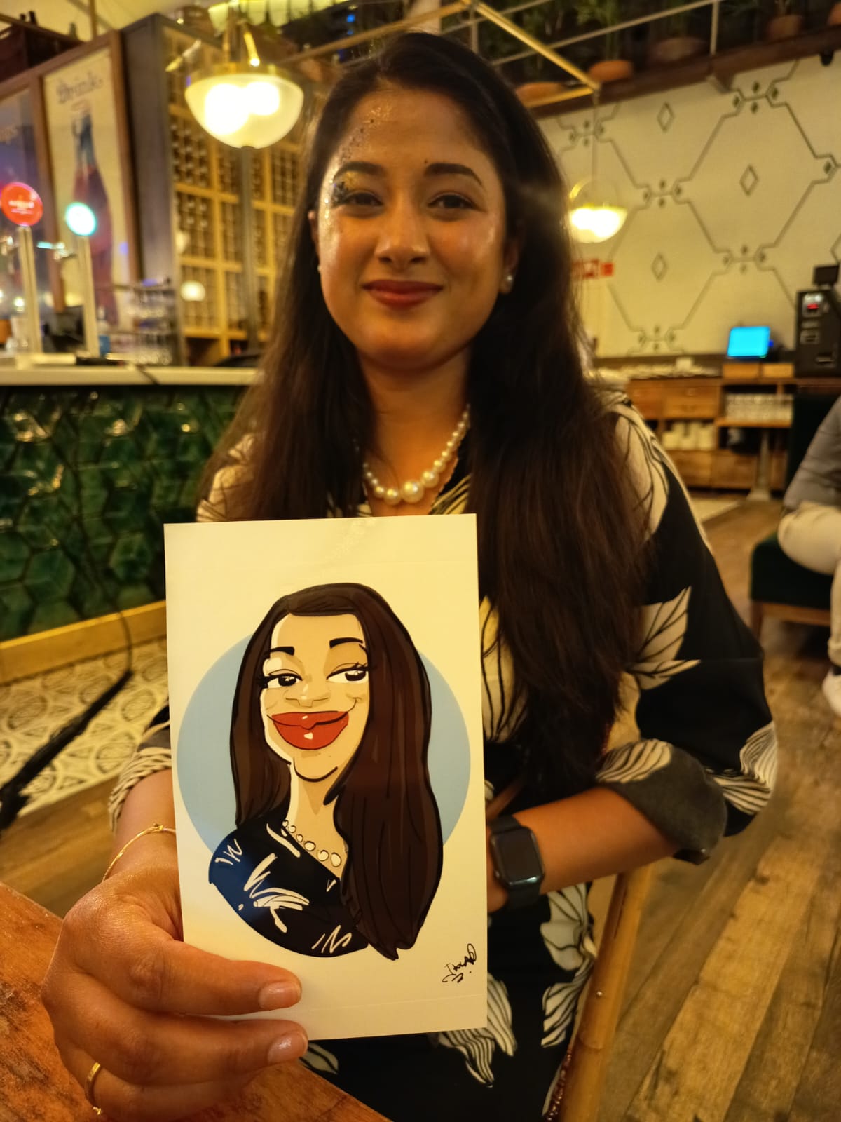 Invitada mostrando su caricatura digital recién impresa en un evento