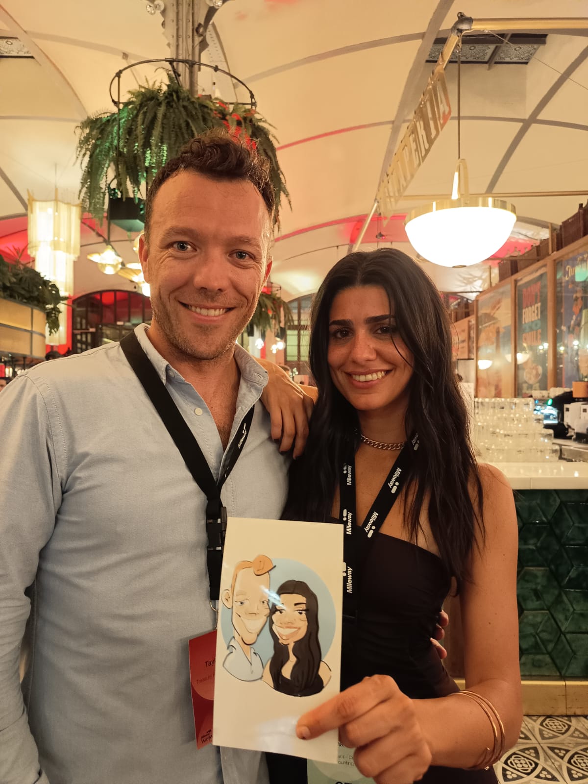 Pareja de invitados con su caricatura en pareja durante un evento