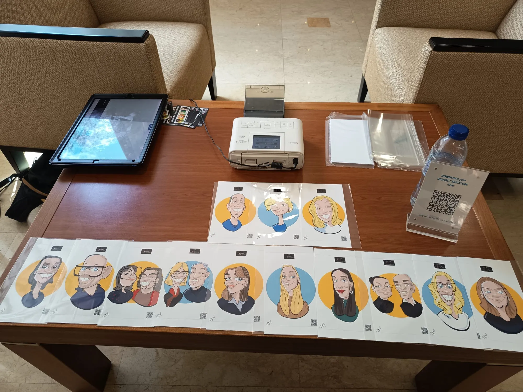 Mesa del caricaturista digital con tablet, impresora y código QR de descarga