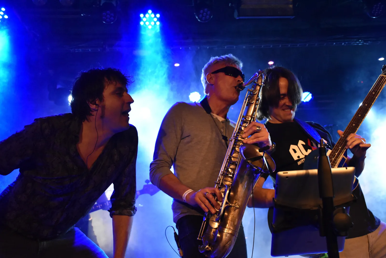 Cantante, saxofonista y guitarrista de The Hots en directo bajo focos azules