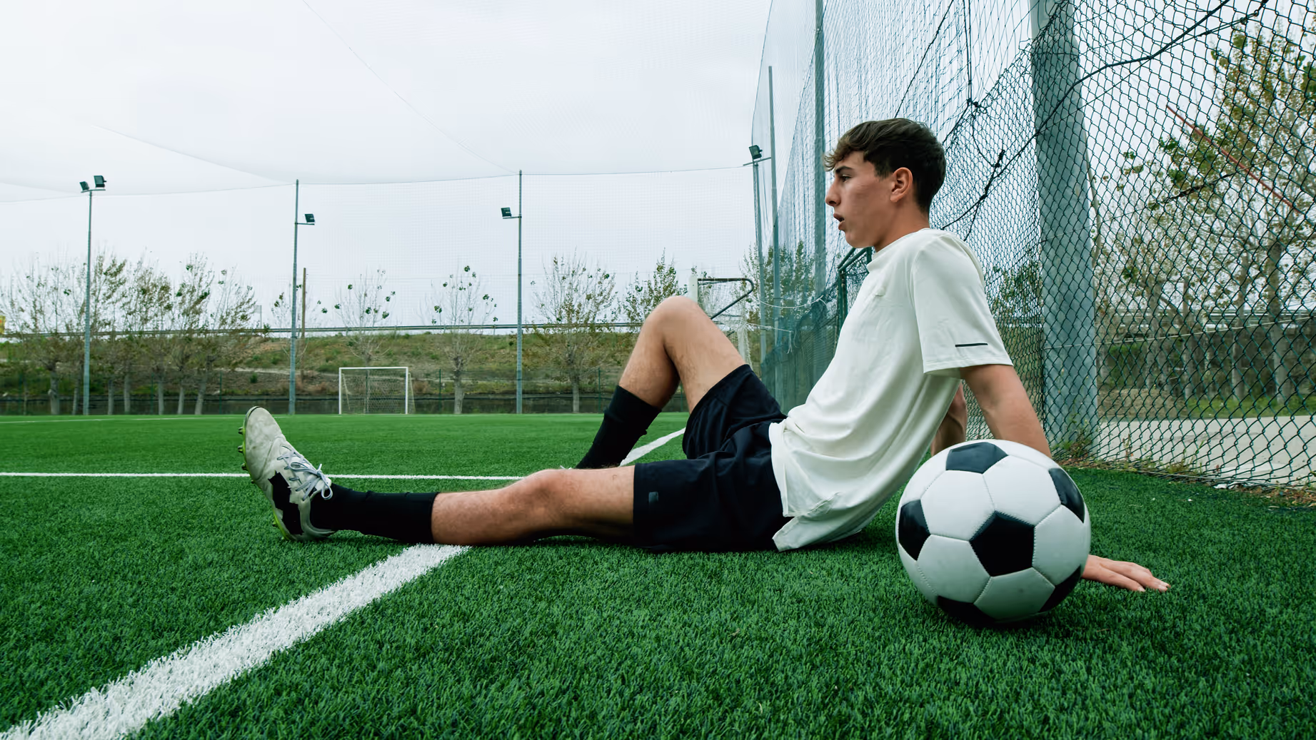 Teen soccer player resting on the field