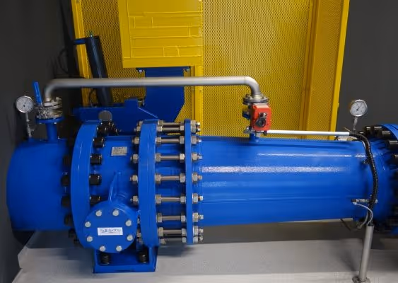 Industrial blue cylindrical machine with gauges and connected pipes, set against a yellow mesh background.