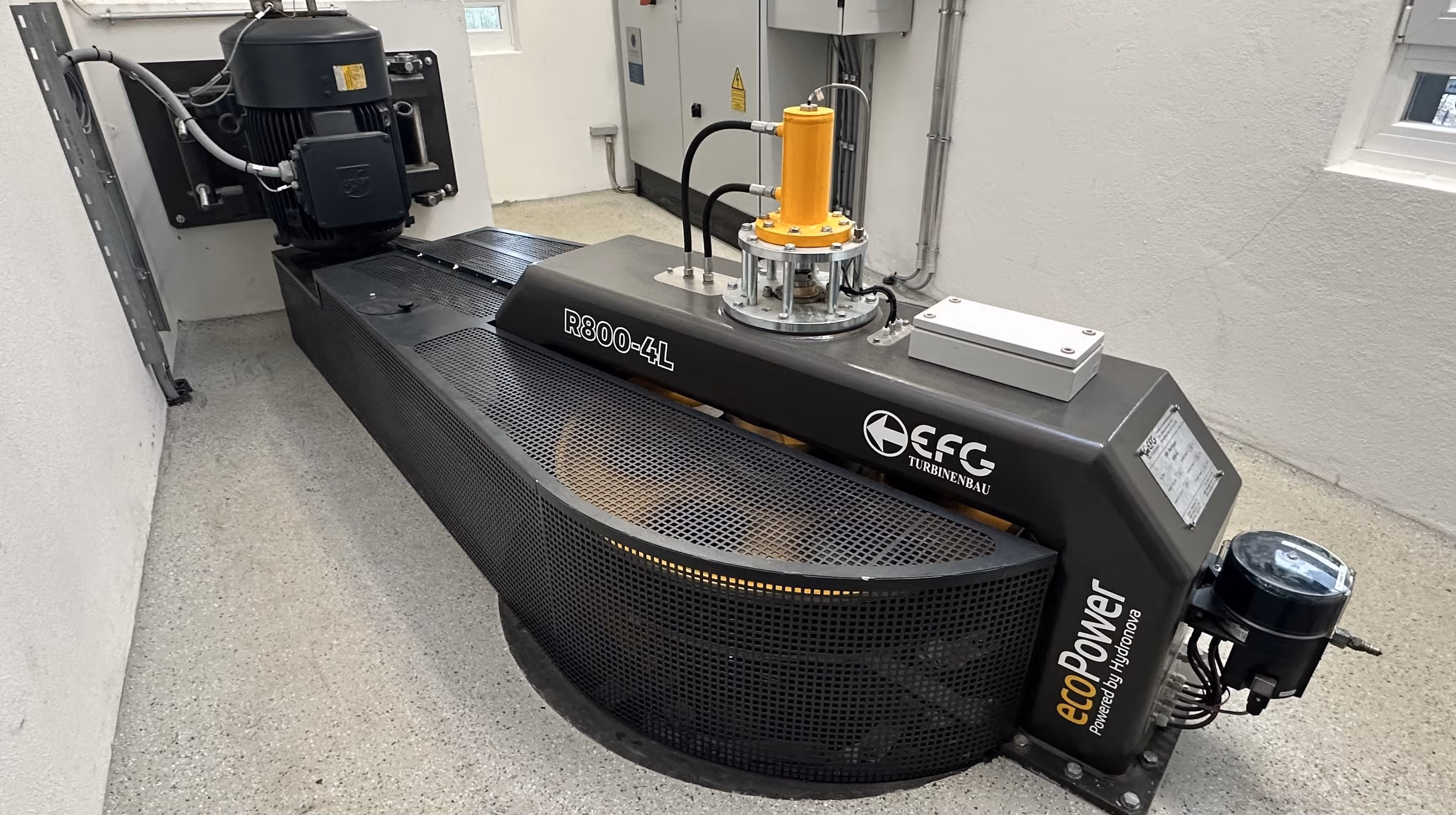 Industrial ecoPower R800-4L turbine machine with protective mesh cover inside a facility room.