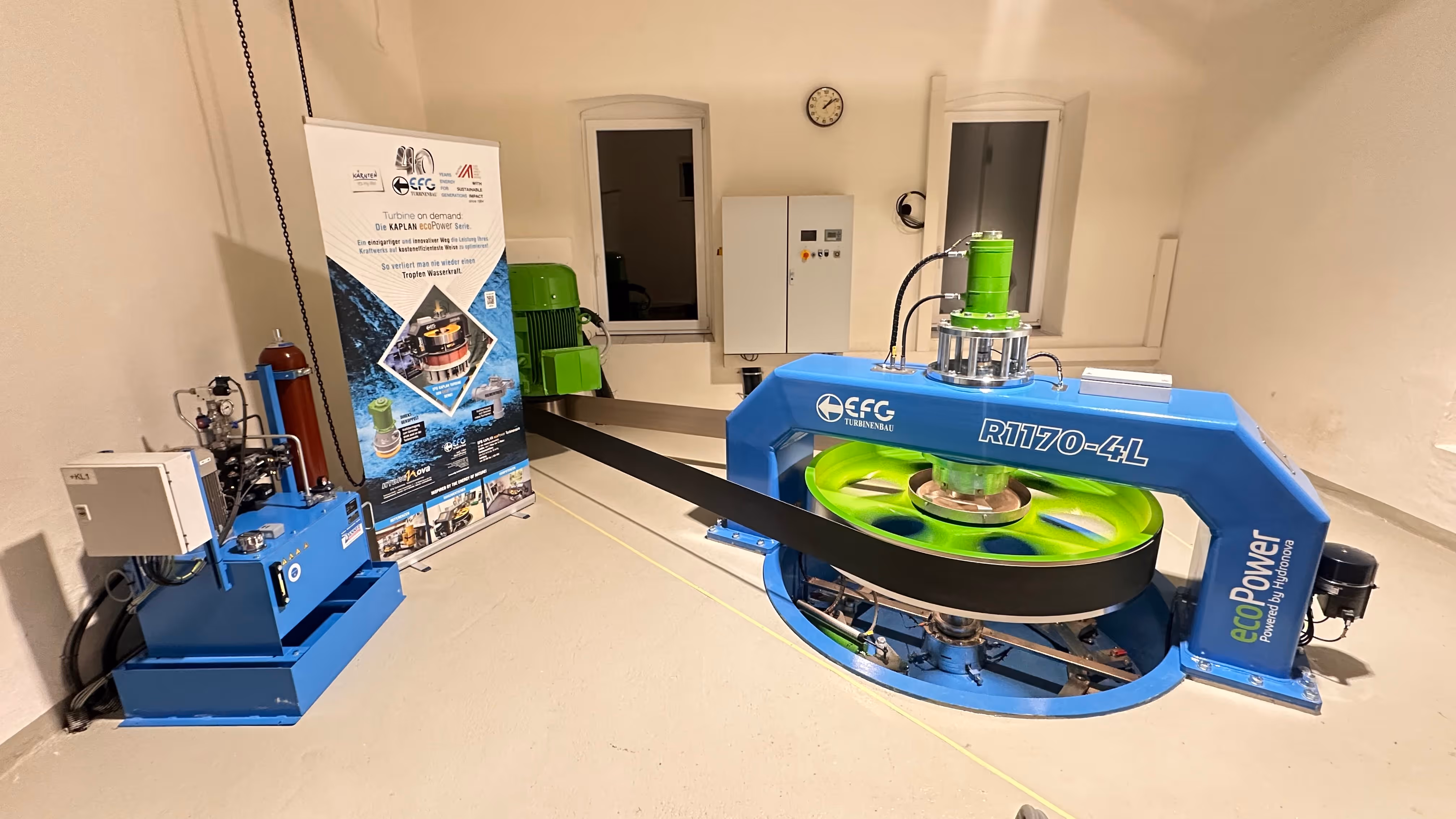 Industrial room housing a blue and green EcoPower R1170-4L turbine system with control panel and promotional banner.
