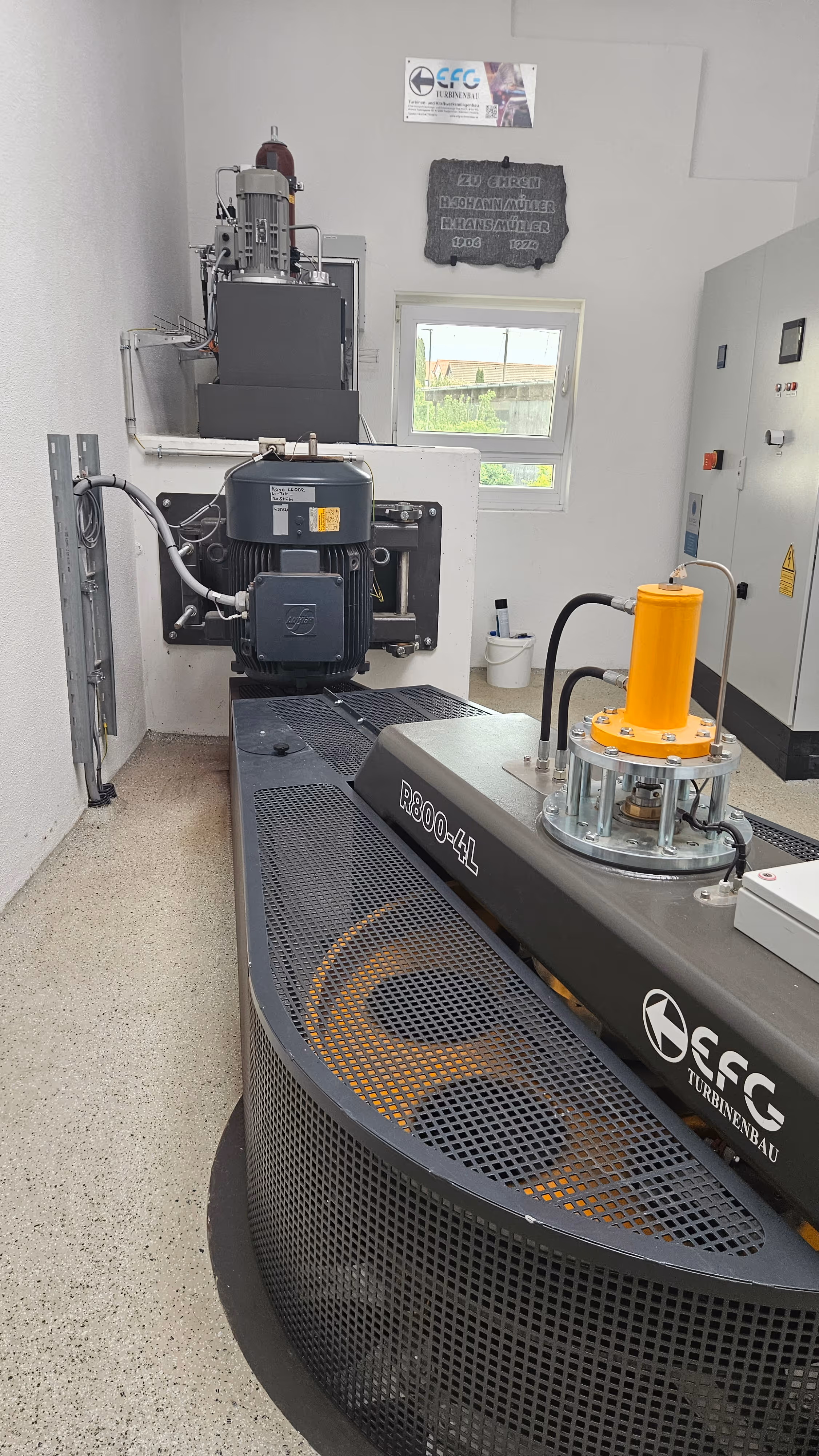 Industrial EFG Turbinenbau R800-4L turbine testing setup inside a white-walled room with control cabinets and a window.