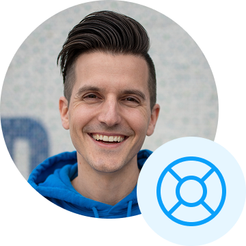 A man in a blue hoodie smiling.