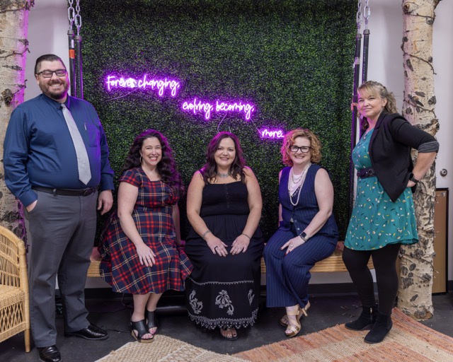 Five leaders smlie against a grass background.