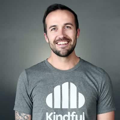 Smiling man with short dark hair and beard wearing a gray Kindful t-shirt.