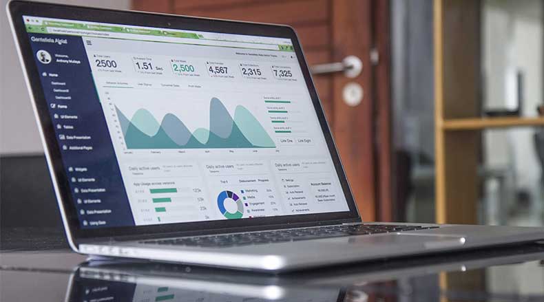 Laptop screen showing a dashboard with charts, graphs, and statistics for user analytics.