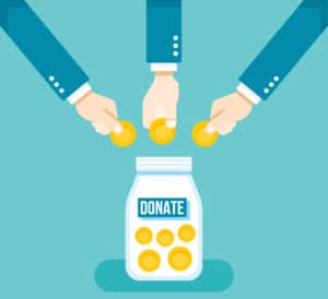 Hands dropping coins into a jar labeled Donate, symbolizing charitable giving.