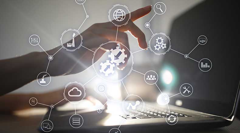 Hand interacting with floating tech icons like gears, cloud, and graphs above a laptop keyboard.