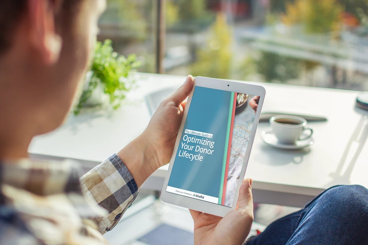 person holding ipad with donor lifecycle ebook