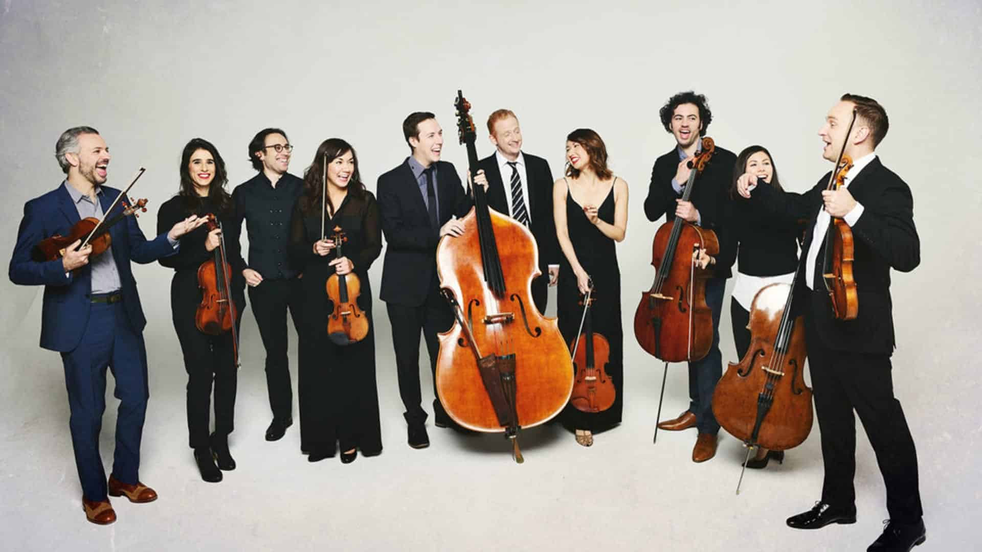 Ten musicians in formal attire holding different string instruments.
