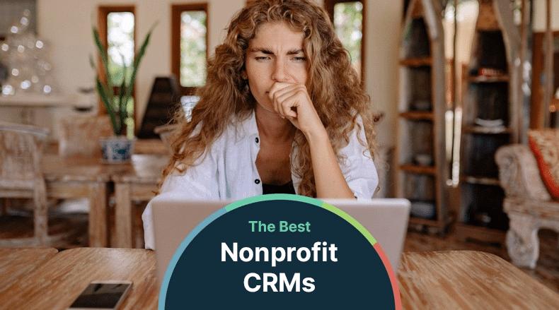 Woman with curly hair looks thoughtfully at a laptop with a screen showing The Best Nonprofit CRMs text.