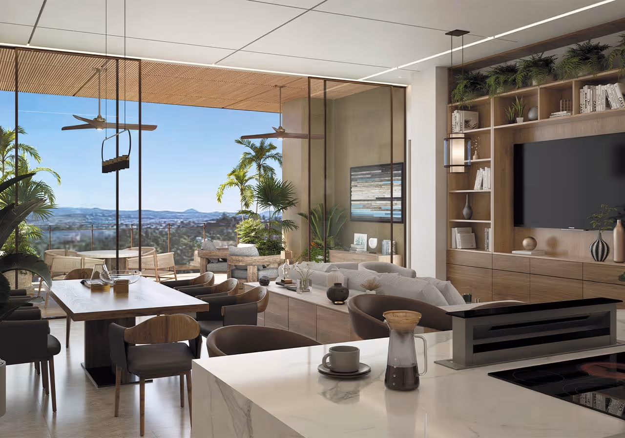 Sala y comedor modernos con techo blanco, muebles de madera, sofá gris, TV montada, y vista panorámica a zonas verdes y montañas a través de grandes ventanales de cristal.