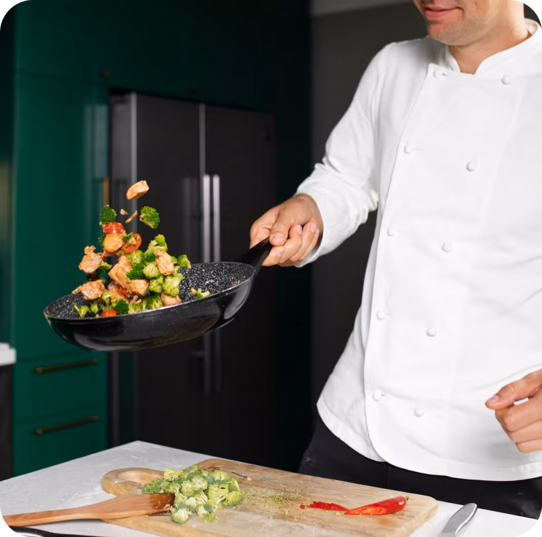 Foodballers persönlicher Koch bereitet frische Sporternährung mit Gemüse in moderner Küche für Profisportler in der D-A-CH Region zu