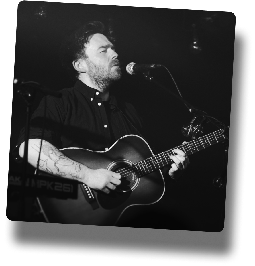 Billy Kennedy on stage playing guitar