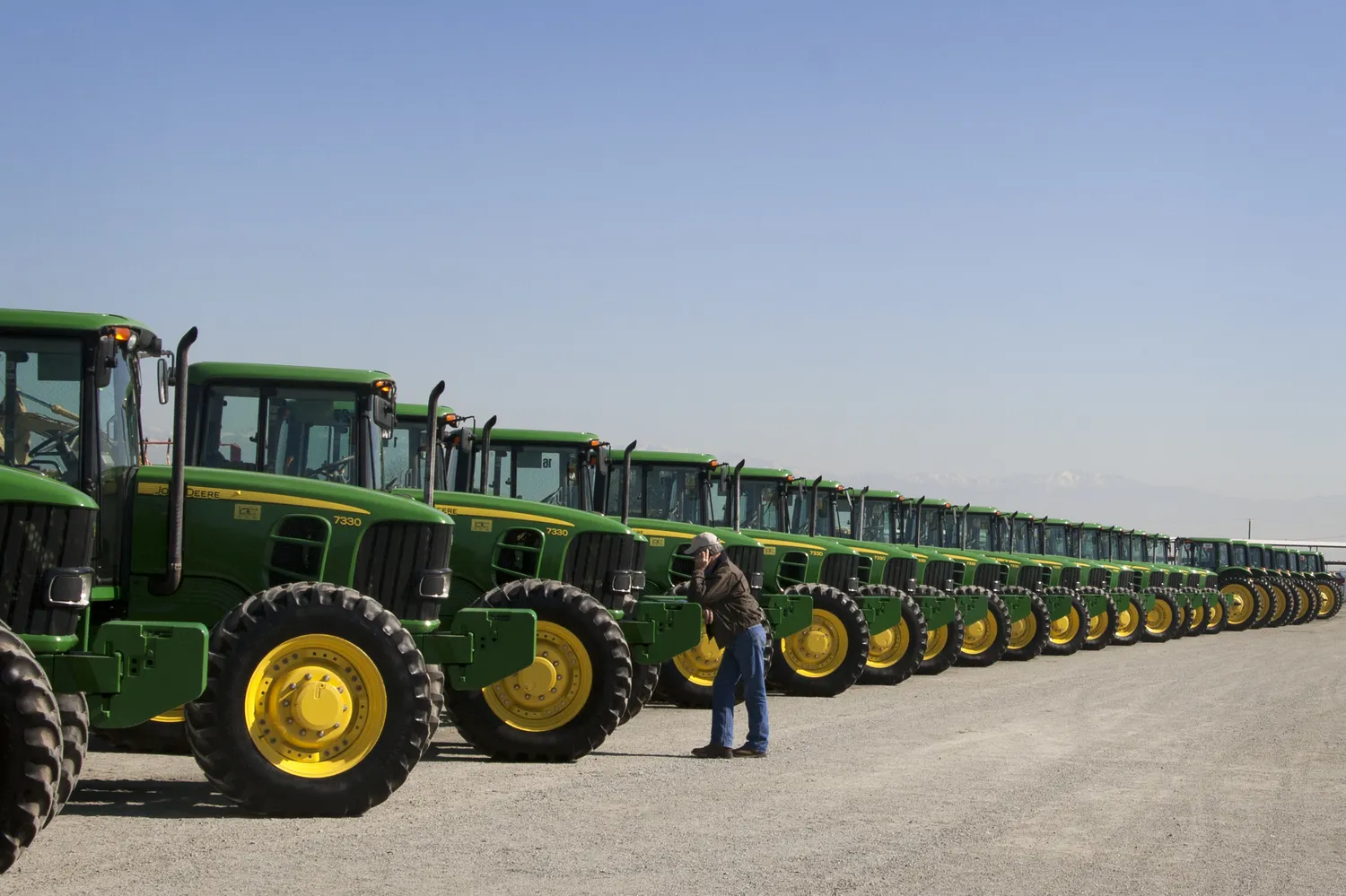 Rows of tractors with a person inspecting one