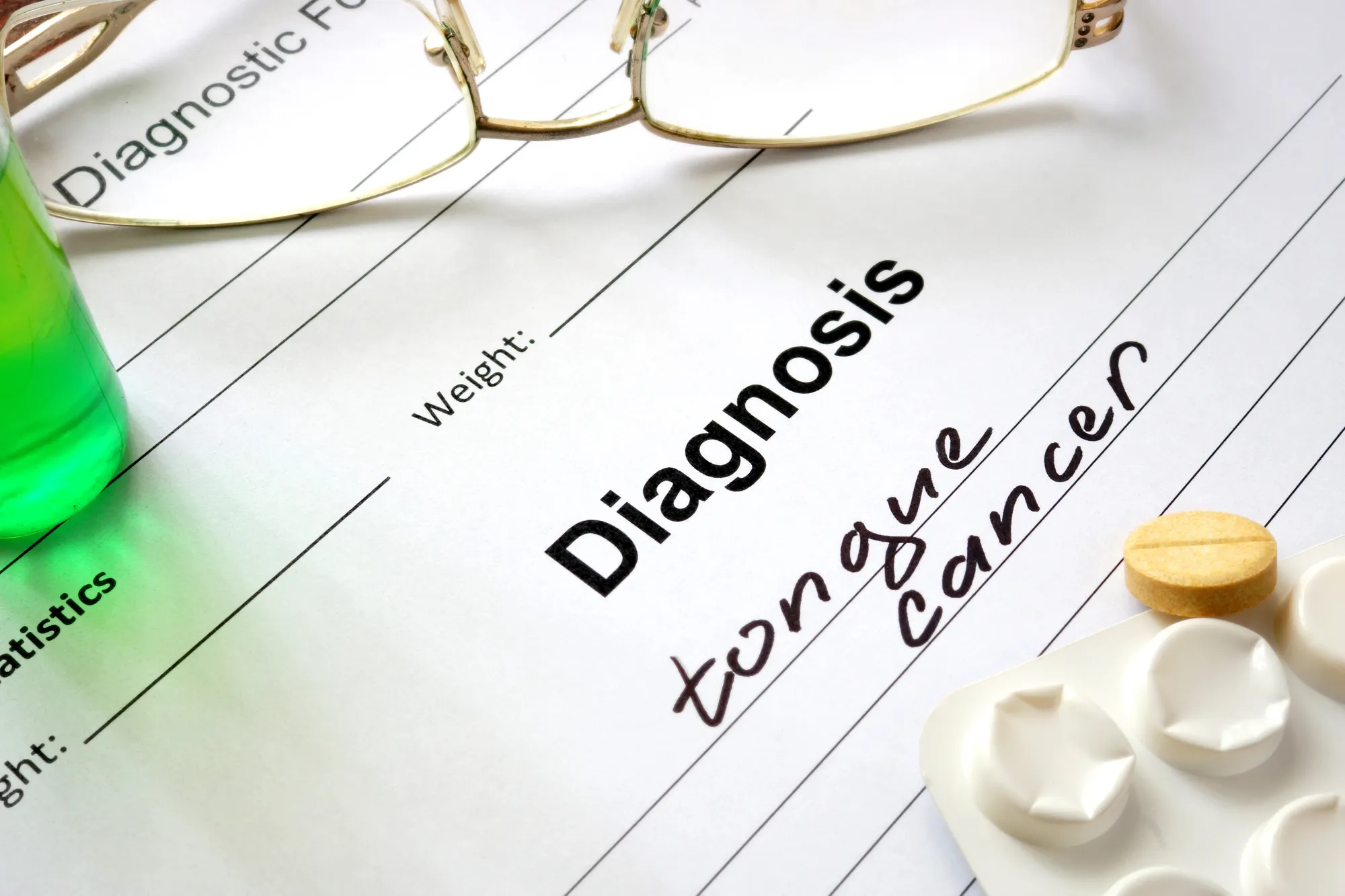 Medical form with handwritten diagnosis of tongue cancer next to glasses, a pill, and a green bottle.