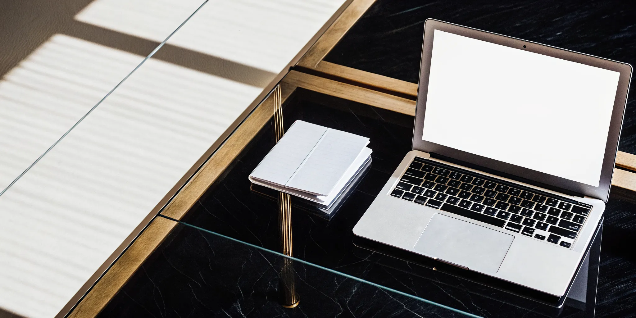 A manager's desk with a laptop for an AI coach and a notebook for a human coach.