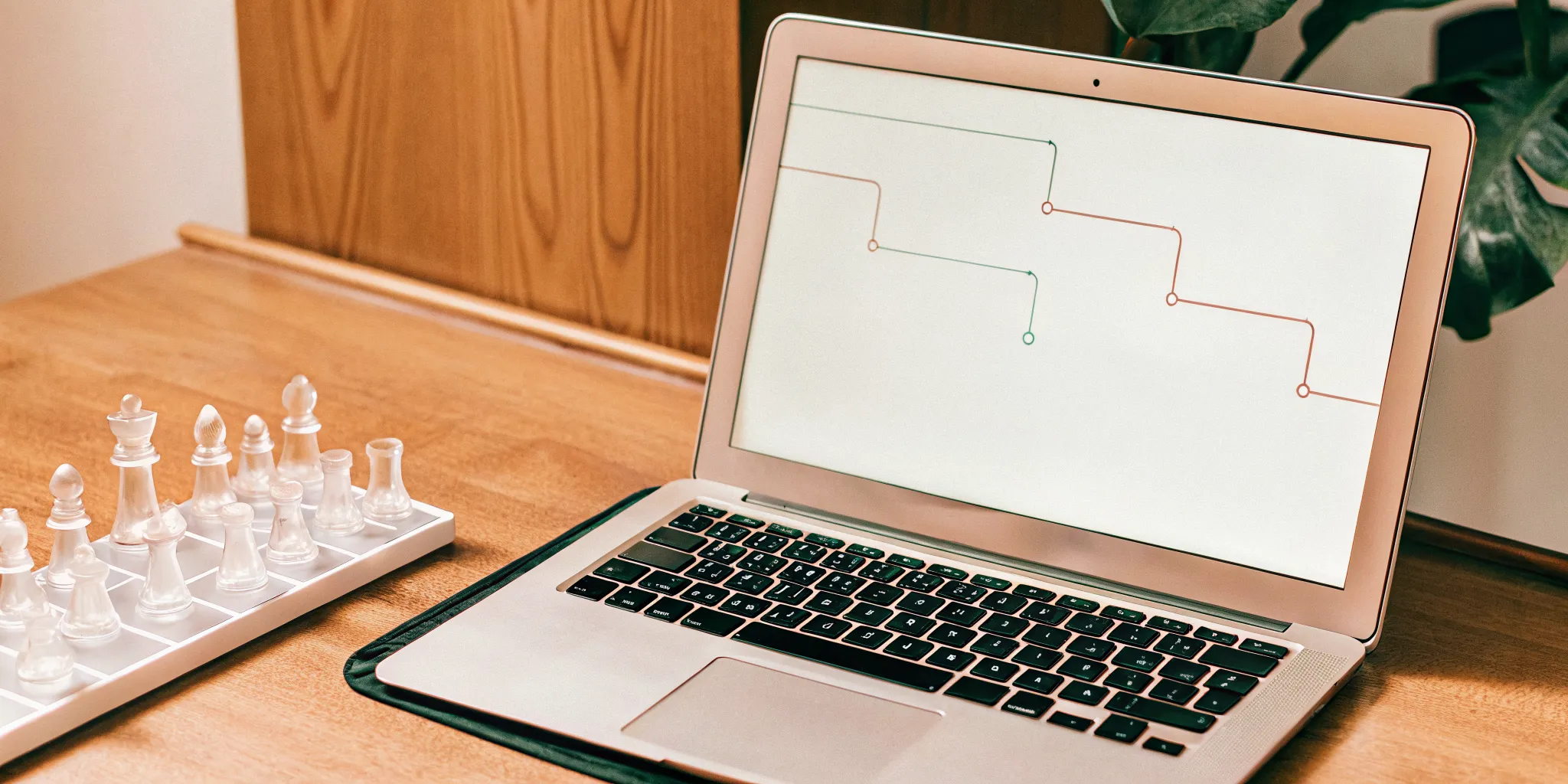 A laptop with a progress chart and chess set for the best virtual coaching for new leaders.