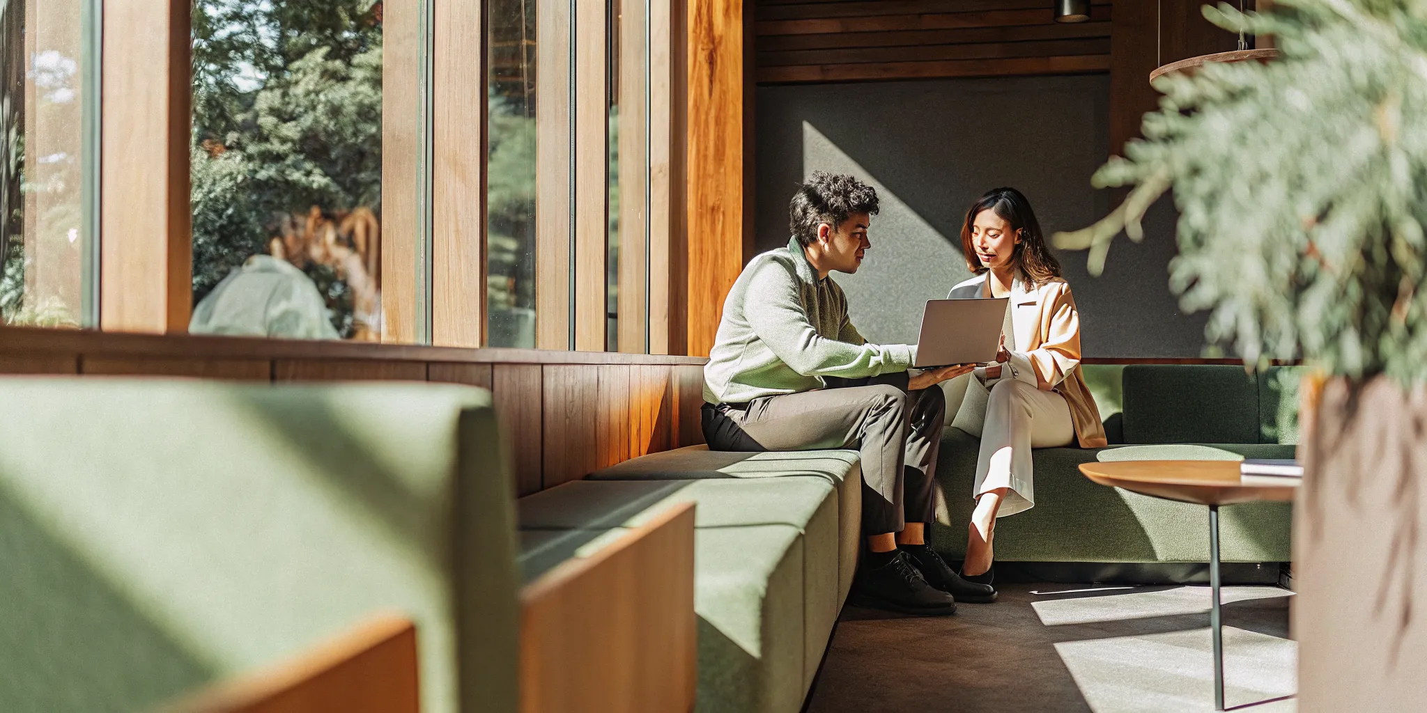 A manager and employee having a positive coaching conversation in a modern office workspace