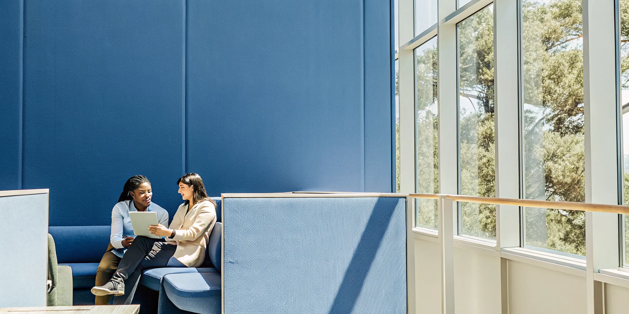 A young professional manager giving encouraging, constructive feedback to an employee in a modern corporate workspace