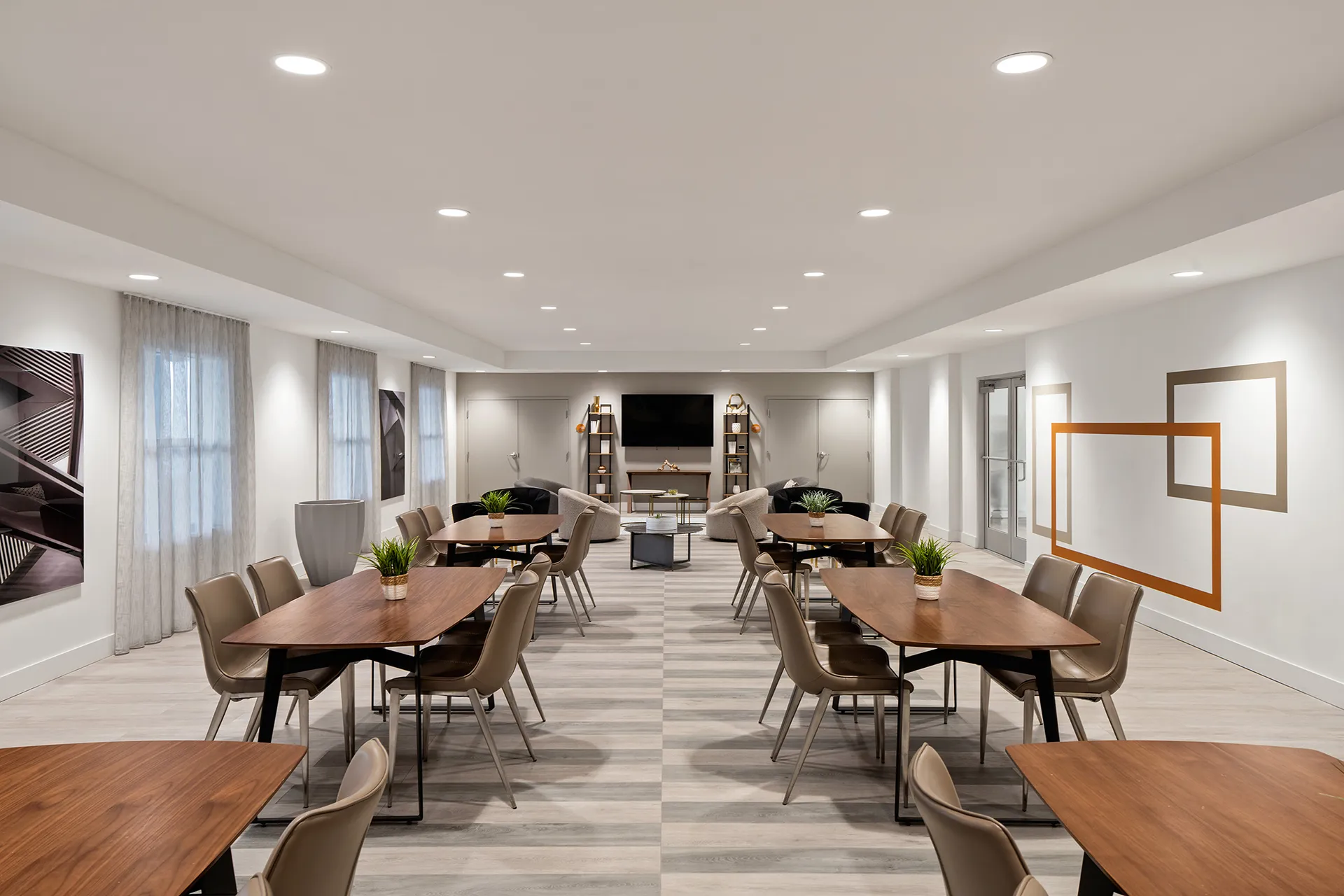 community room with tv, chairs, and tables