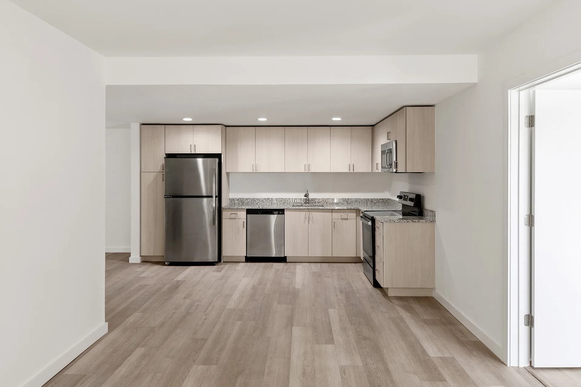 kitchen with stainless steel appliances and view of dining area unfurnished 