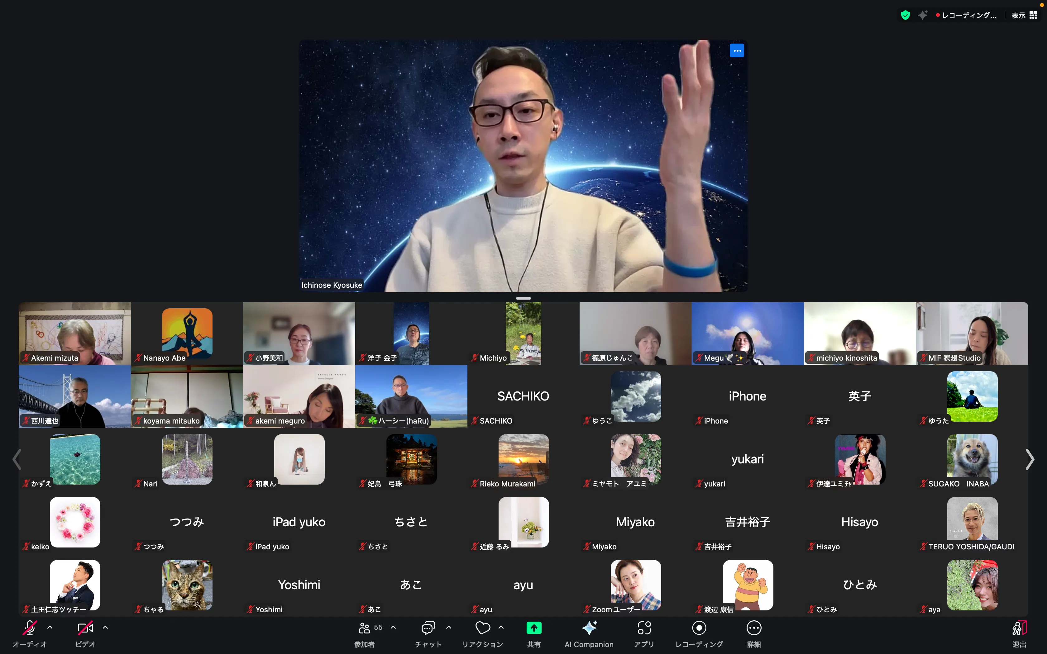 ビデオ会議の画面で、講演者が宇宙と地球を背景に話している様子と、多数の参加者のサムネイルが表示されています。