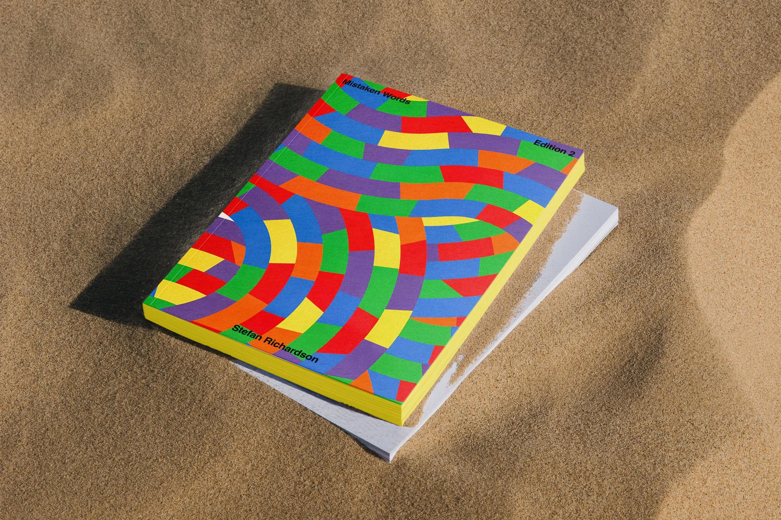 Colourful books stacked in the sand