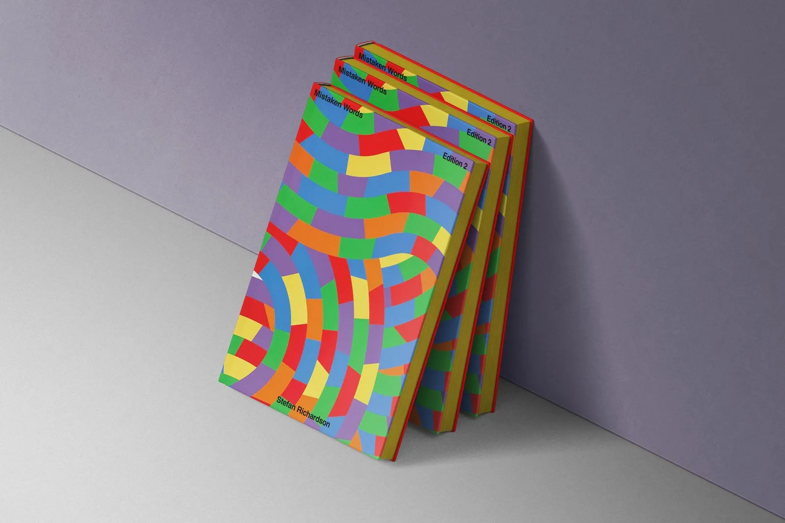 Colourful books stacked against a purple wall