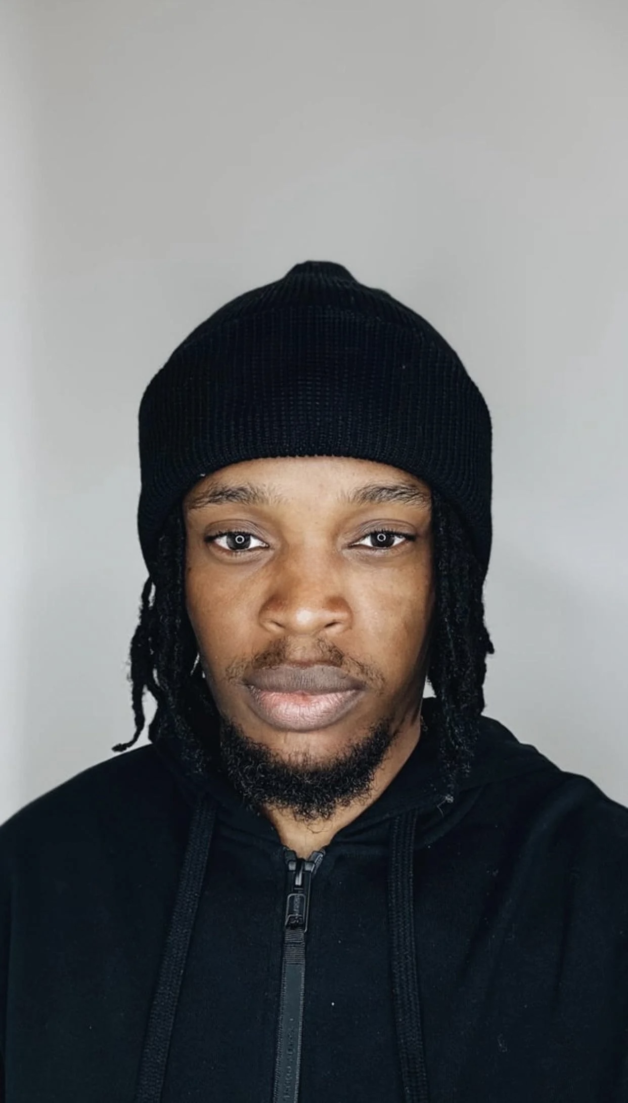 Middle-aged man wearing a dark green polo shirt, looking to the side against a beige background.