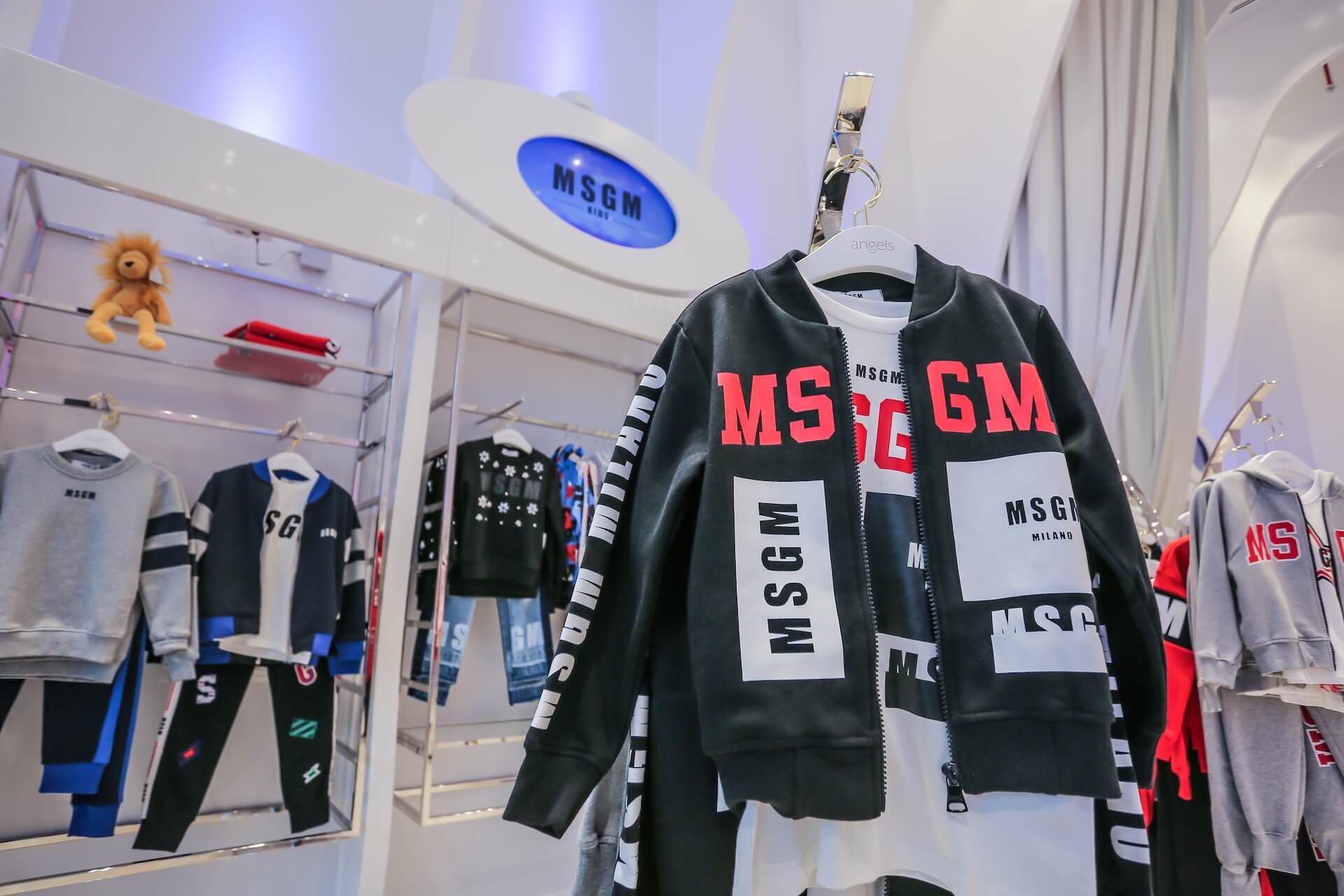 MSGM Milano retail store displaying children's clothing with black and red branded jacket on hanger