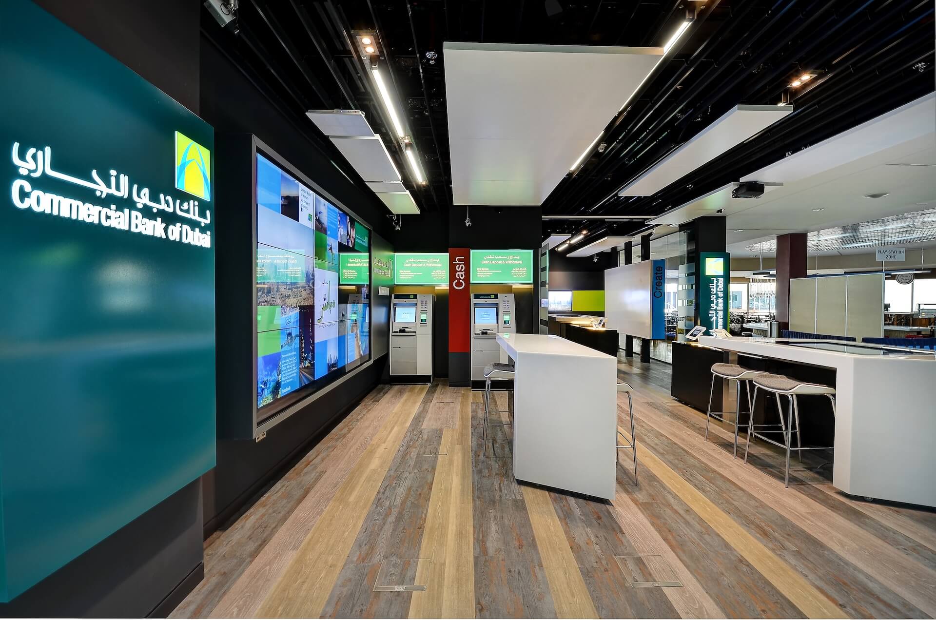 Modern Commercial Bank of Dubai branch interior with ATMs, service counters, and digital displays.