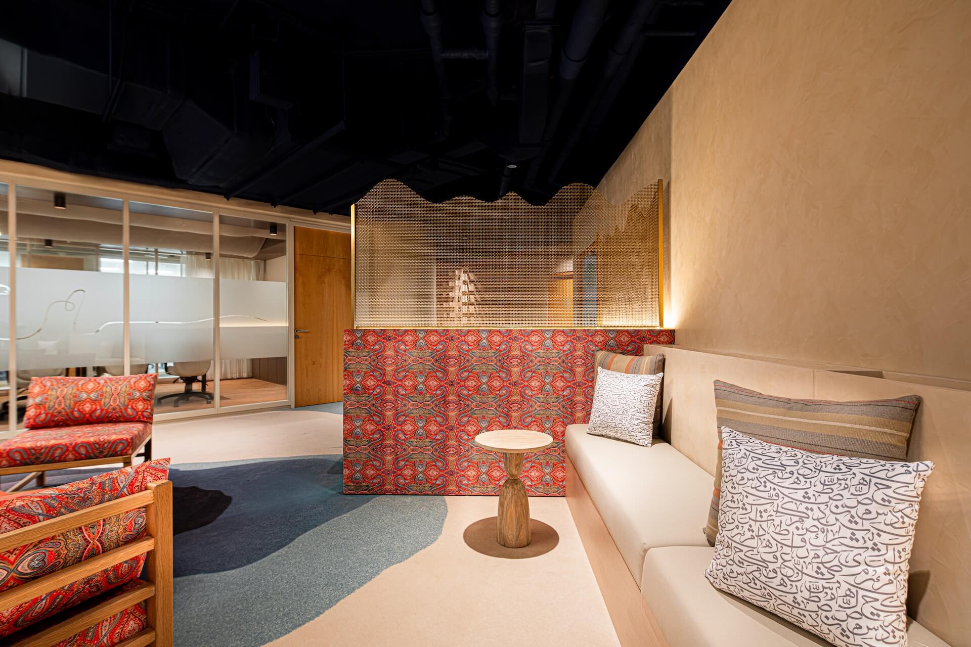 Modern interior design showroom with warm lighting, red patterned furniture, and wooden accents