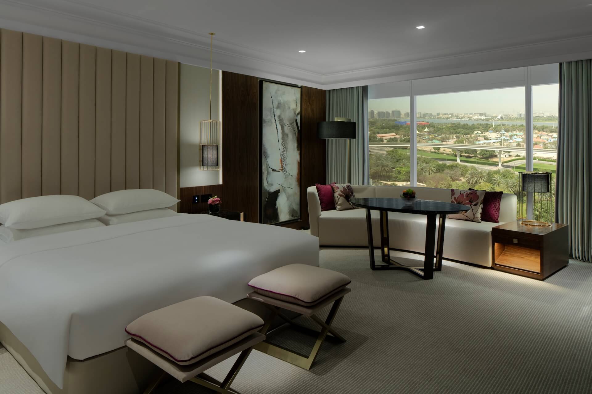 Luxury modern hotel room with bed, seating area, and panoramic city skyline view