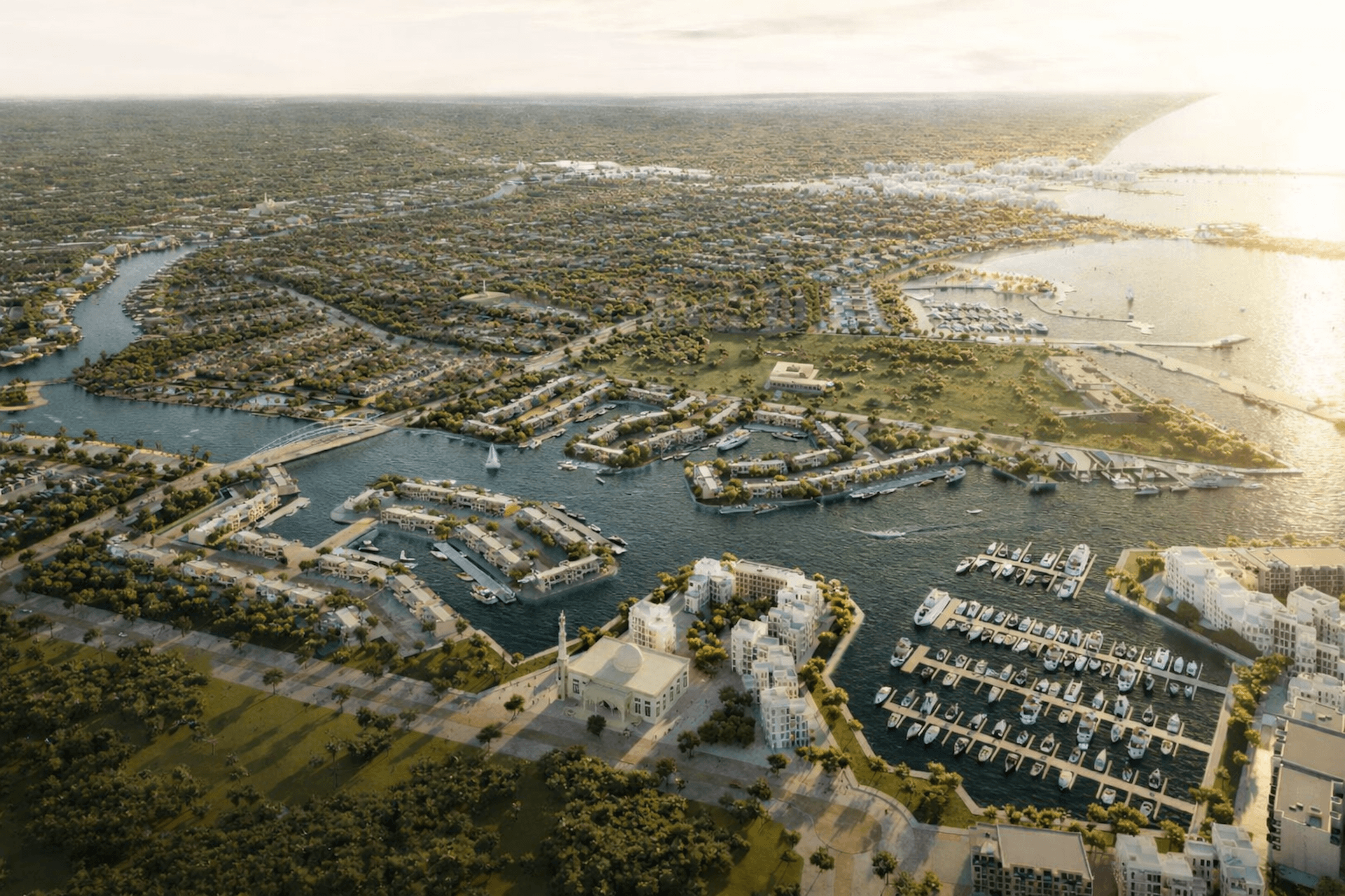 Aerial view of waterfront community with marinas, residential buildings, and winding waterways surrounded by greenery.
