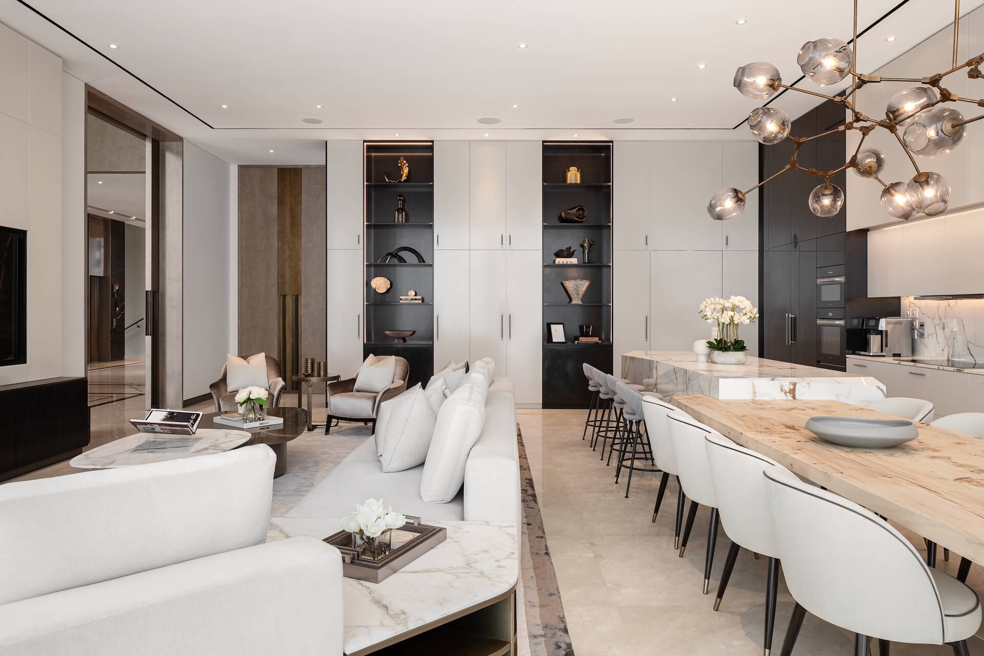Modern luxury open-plan kitchen and living room with marble surfaces and contemporary pendant lighting