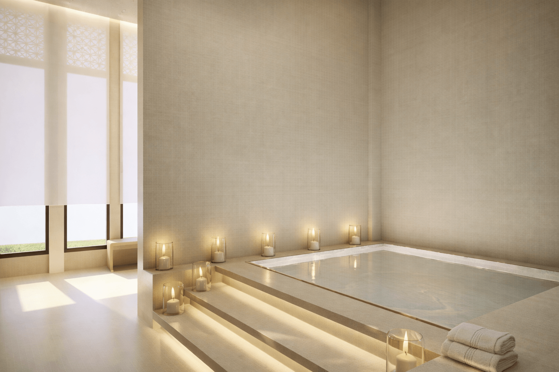 Modern spa bathroom with sunken bathtub, candles, and beige minimalist design.