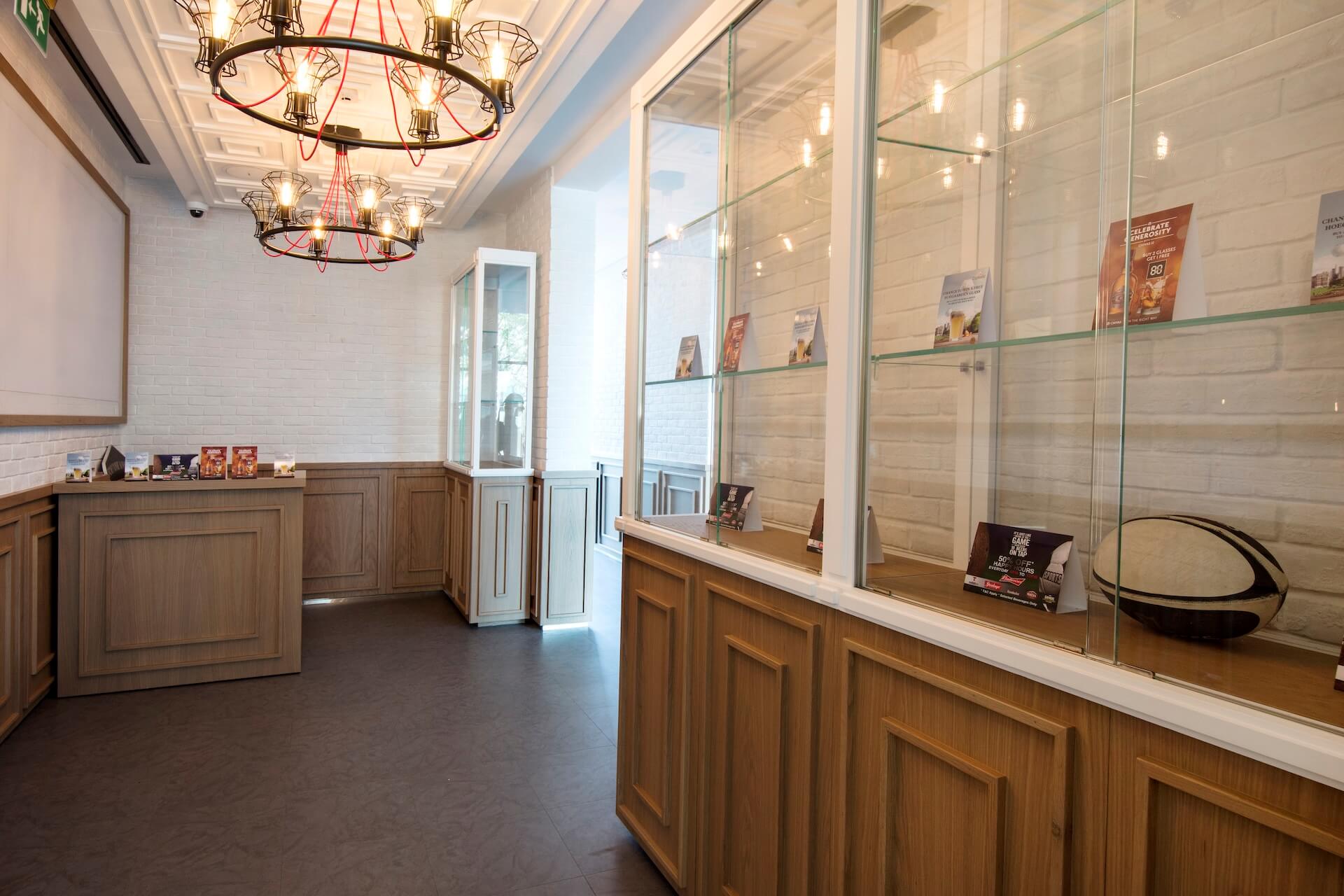 Modern retail store interior with wooden display counters, glass cases, and decorative ceiling lights