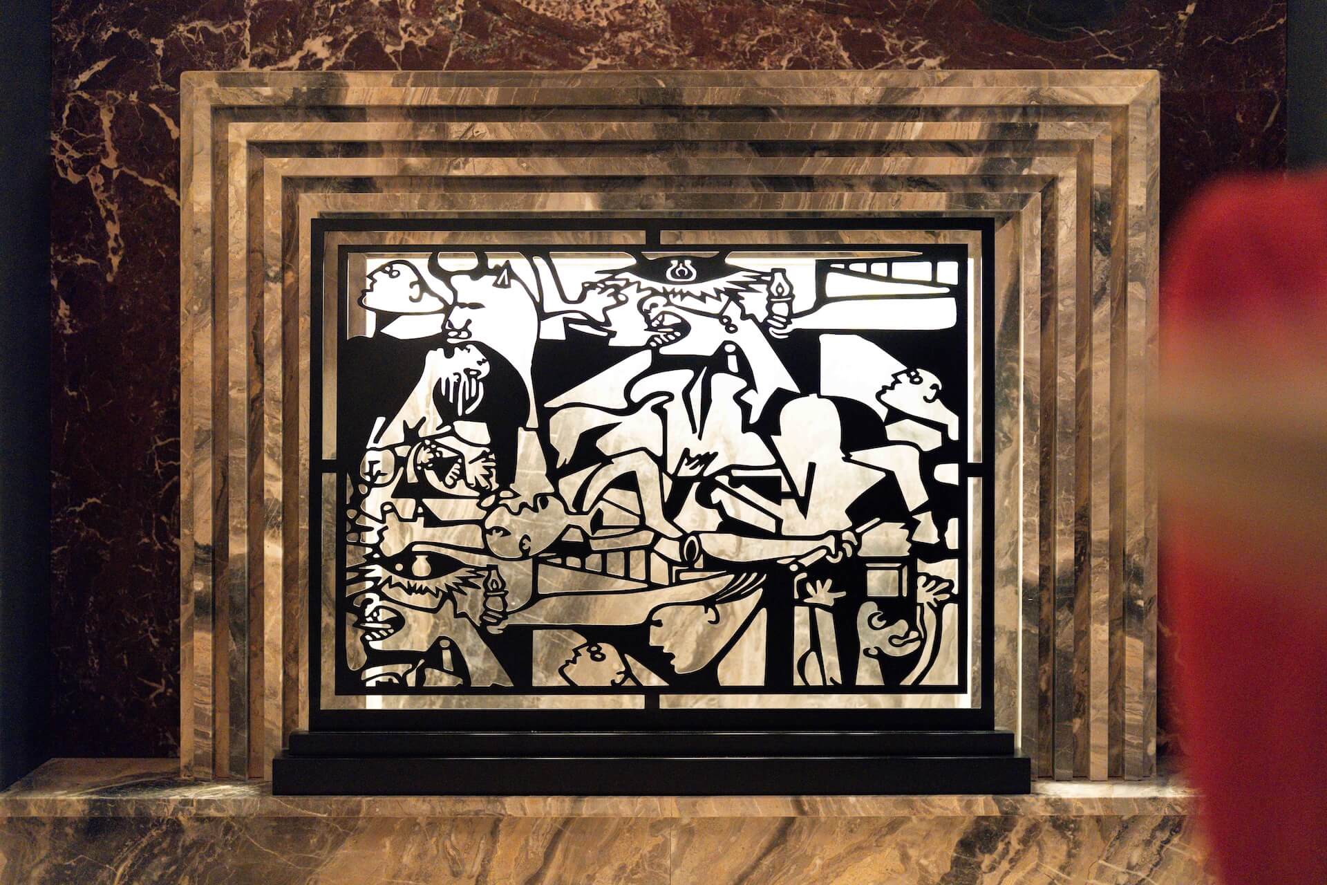 Cubist black and white relief artwork in layered marble frame on marble background