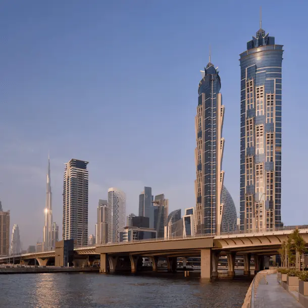 Modern skyline with tall skyscrapers and bridge over waterfront at sunrise