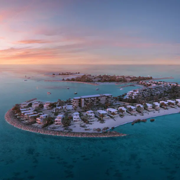 Aerial sunset view of tropical resort peninsula with white villas and turquoise waters