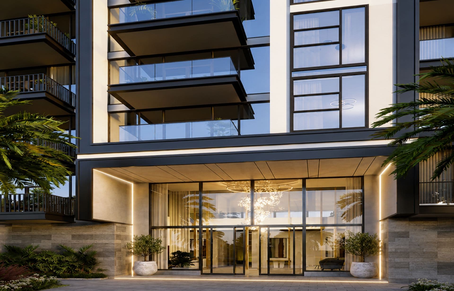 Modern luxury apartment building with glass entrance, balconies, and tropical landscaping at dusk.