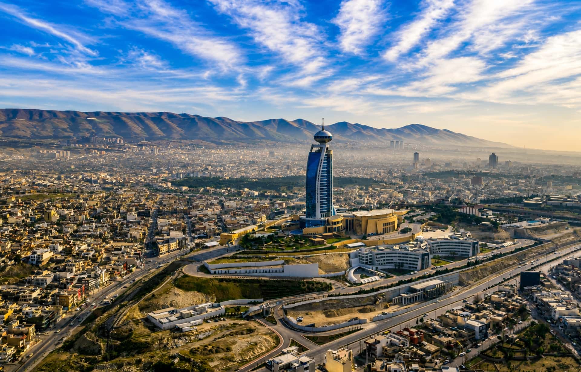 Aerial view of Tehran with distinctive blue tower overlooking sprawling city and mountains