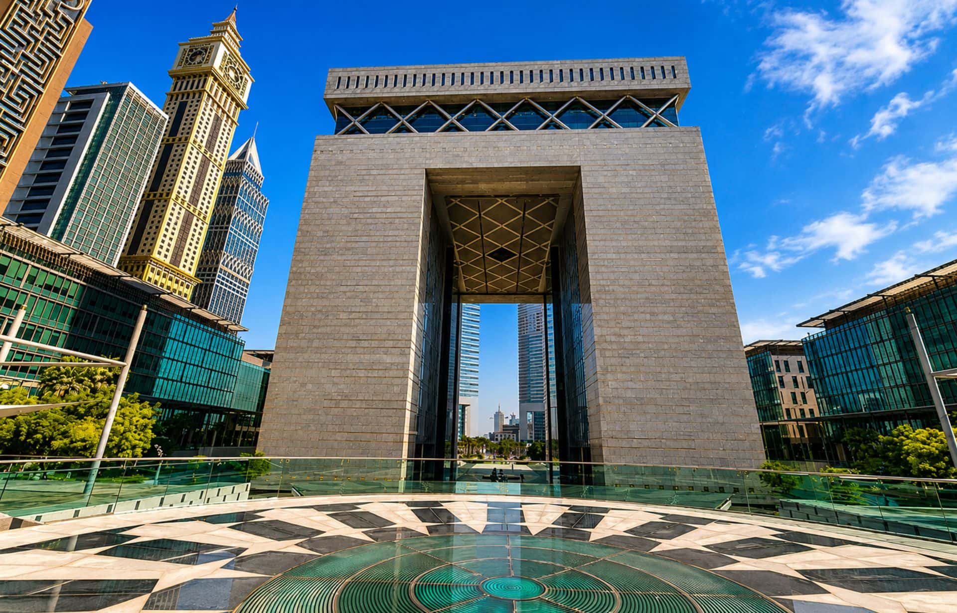 Modern stone gateway structure with open archway in downtown cityscape under blue sky